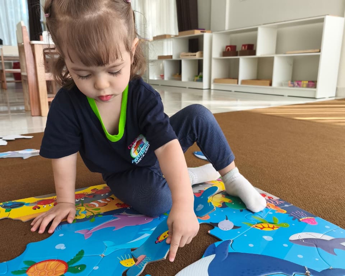 Niño pequeño concentrado jugando con bloques geométricos en la guardería Casita Montessori