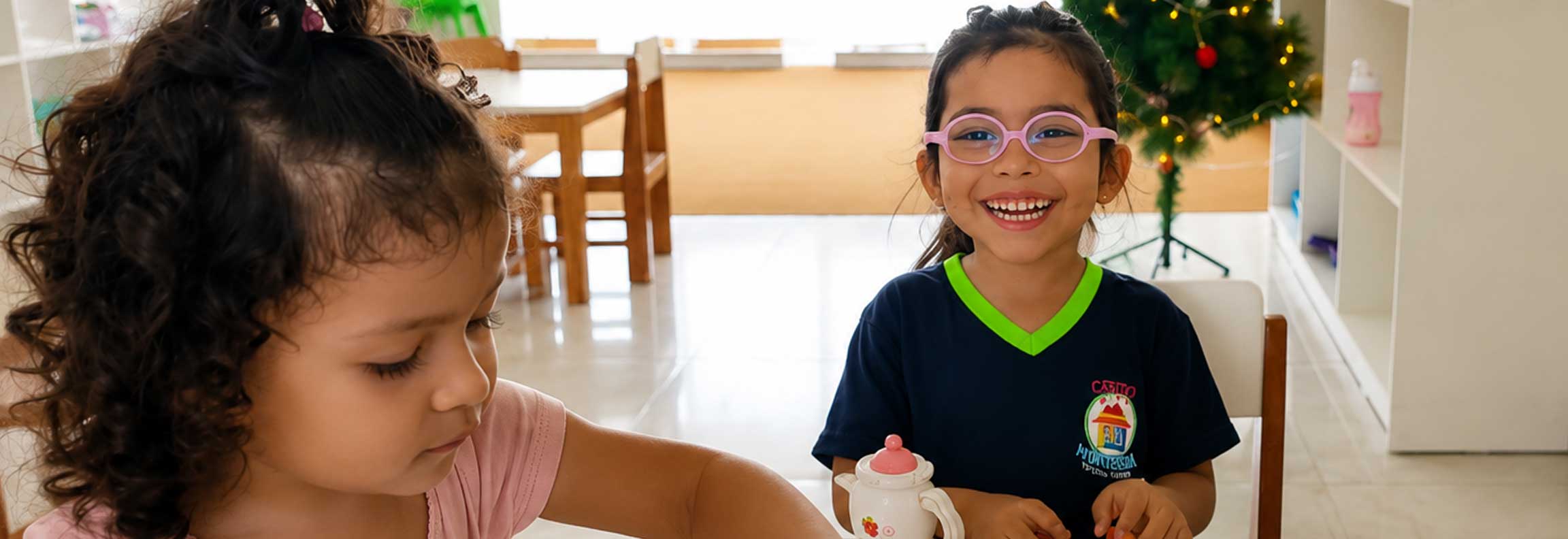 Niños dibujando y trabajando juntos en una mesa en el ambiente Montessori